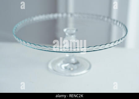 Glass cake stand on white table isolated on white background Stock Photo
