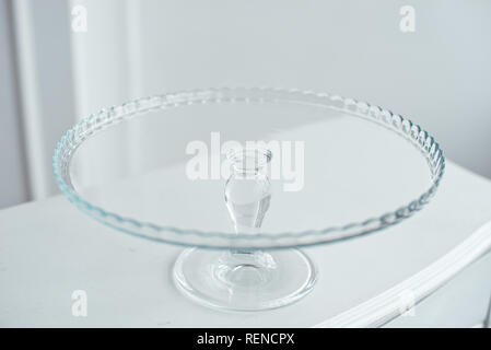 Glass cake stand on white table isolated on white background Stock Photo