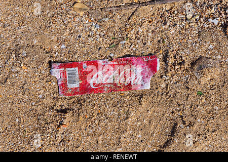 Birkirkara, Malta - December 31, 2018: Plastic label from bottle of Coca-Cola on sandy beach after storm. Plastic pollution problem environment pollut Stock Photo