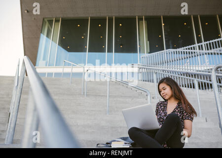 Young Asian college student using a laptop on campus Stock Photo