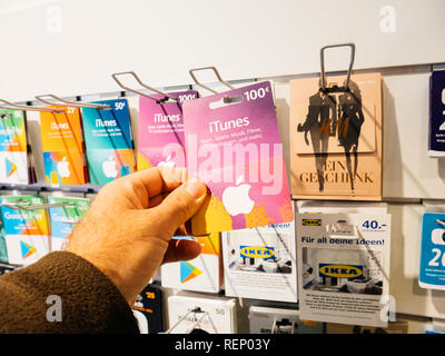 FRANKFURT, GERMANY - OCT 6, 2017: Man hand point of view customer shopping for the prepaid 100 euro card online money prepaid cards on a shelf online applications and computer online store from shell Stock Photo