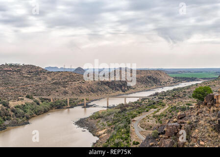 View downstream of the Vanderkloof Dam in the Orange River on the border of the Free State and Northern Cape Provinces. The single lane road bridge is Stock Photo