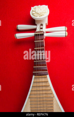 Pipa Chinese guitar, four-stringed lute with 30 frets and pear-shaped body, on red background Stock Photo