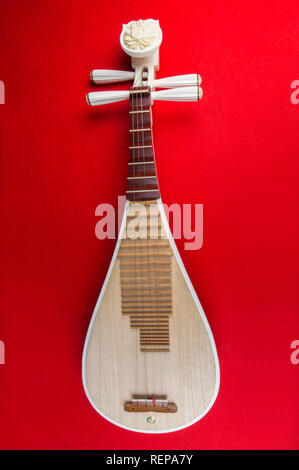 Pipa Chinese guitar, four-stringed lute with 30 frets and pear-shaped body, on red background Stock Photo