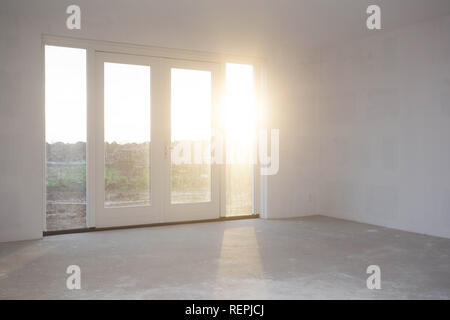 Empty room with big window , frame and double doorsnew construction, still in progress with sunlight shining Stock Photo