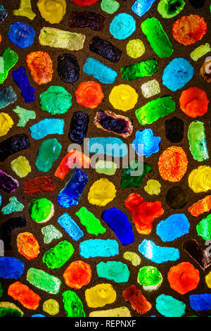 Pieces of colored glass embedded in concrete wall and back-lit Stock Photo