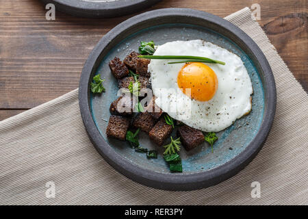 Breakfast with fried egg and croutons, close view copy space Stock Photo