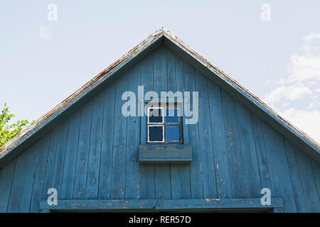 Old rustic blue painted wooden barn garage facade in late spring. Stock Photo