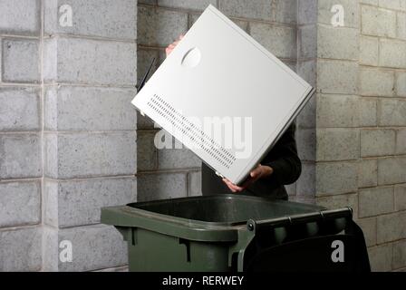 Disposing of obsolete computer technology in a wheelie bin Stock Photo