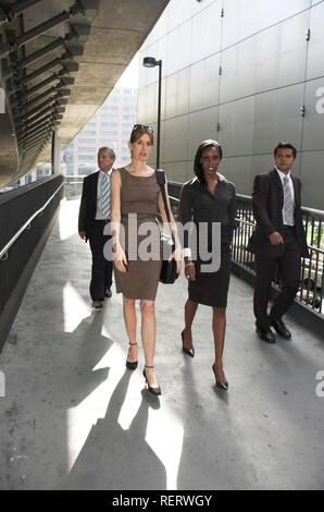 Group of business people walking through an urban passageway Stock Photo