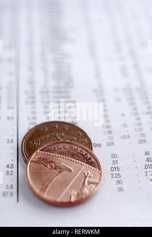 Close up of one penny coins over stock prices Stock Photo