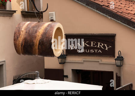 Exterior of a bakery in Prague, Czech Republic, with a large Trdelnik hanging outside Stock Photo