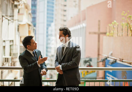 Two business colleagues conversing outside an office building. Stock Photo