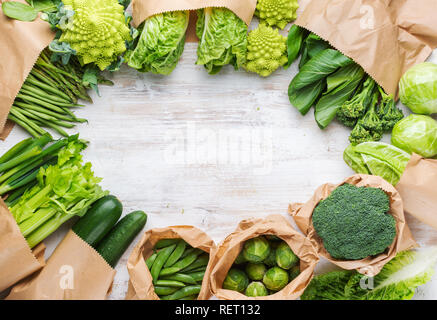 Healthy eating, copy space. Farmers market produce in paper bags. Green vegetables on white table, broccoli sprouts peas avocado courgette celery Stock Photo