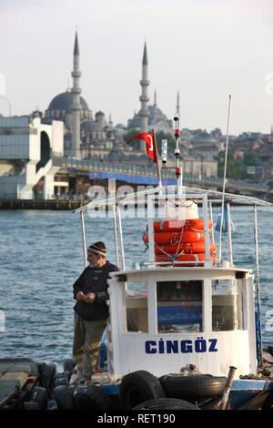 Man, small river ferry at the Golden Horn beside Galata Bridge, Istanbul, Turkey Stock Photo