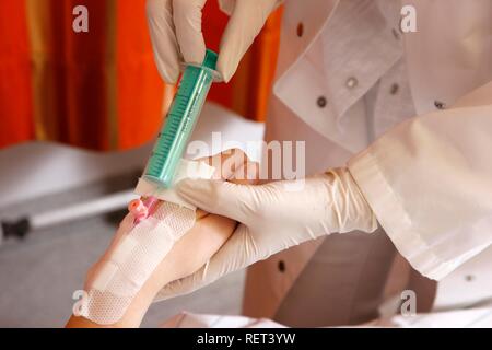 Doctor taking a blood sample from a patient in a hospital Stock Photo