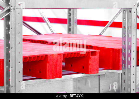 Empty red plastic pallets on racks in an automated warehouse complex Stock Photo