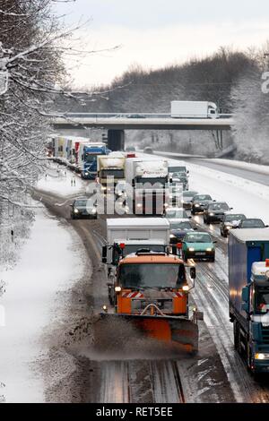 Snow plough in operation, traffic jam after heavy snow fall, motorway Autobahn A40, Ruhr expressway between Duisburg and Essen Stock Photo