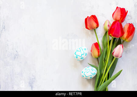Easter table setting with tulips flowers and Easter eggs. Holidays background. Top view flat lay background. Copy space. Stock Photo