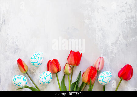 Easter table setting with tulips flowers and Easter eggs. Holidays background. Top view flat lay background. Copy space. Stock Photo