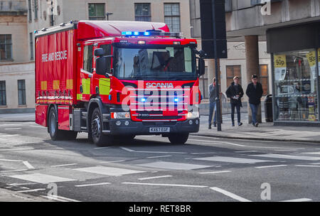 Fire and rescue tender in bright red and with blue lights flashing races down St Aldate's street, Oxford, England. Stock Photo