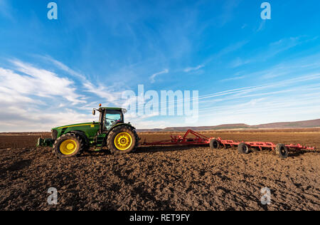 Varna, Bulgaria - March 5, 2017 Ploughing a field with John Deere tractor. John Deere was manufactured in 1995-1999 and it has JD 7.6L or 8.1L 6-cyl d Stock Photo