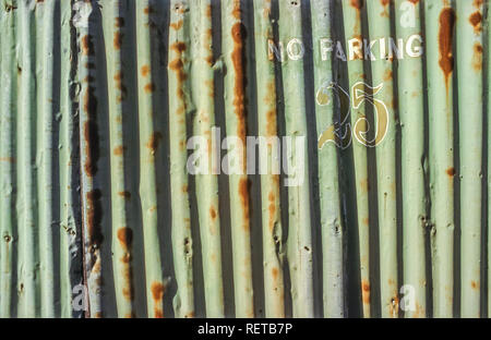 No parking and number 25 painted on a rusted corrugated sheet metal wall Stock Photo