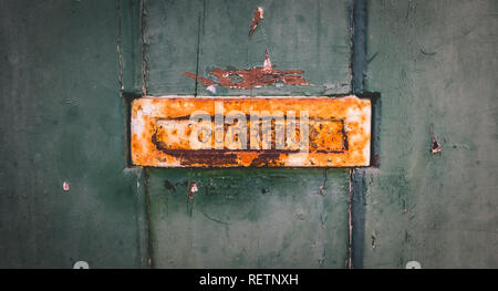 old rusty Portuguese mailbox on a worn wooden door where it is written in Portuguese: mail Stock Photo
