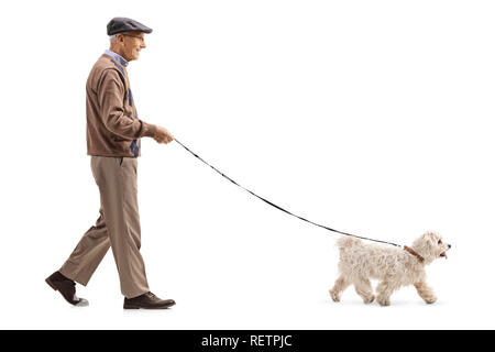 Full length profile shot of a senior walking a dog isolated on white background Stock Photo