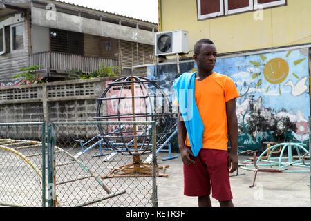 Young black African man thinking with jacket over his shoulder w Stock Photo