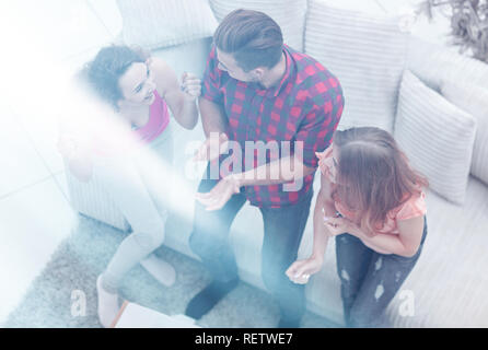 triumphant group of friends laughing while sitting on the couch in the living room Stock Photo