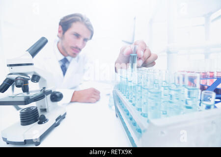 Chemist looking at test-tubes with blue liquids Stock Photo