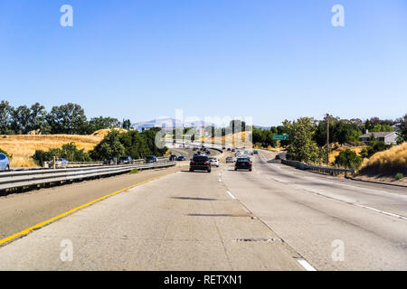 Bright summer day while driving on a road surrounded by greenery and ...