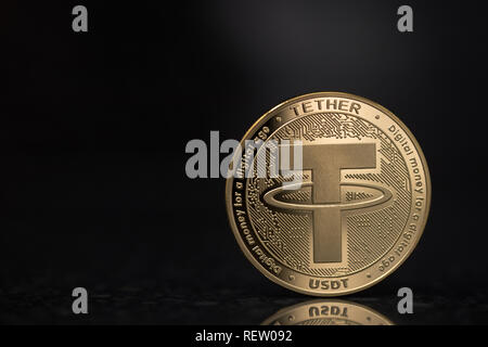 Tether USDT cryptocurrency physical coin placed on the reflective surface in the black background Stock Photo