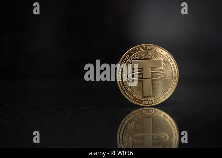 Tether USDT cryptocurrency physical coin placed on the reflective surface in the black background Stock Photo