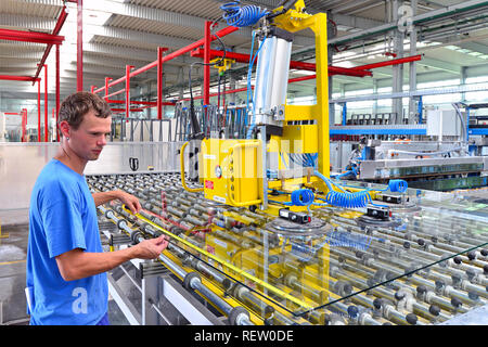 young employee in a company manufacturing safety glass for house construction Stock Photo