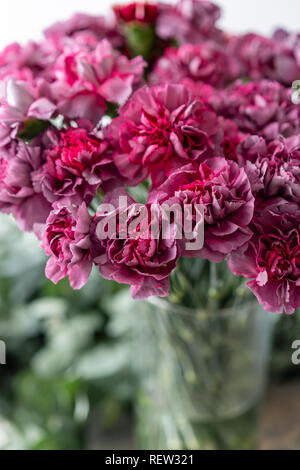 Bunch unusual lilac violet carnation in glass vase. Bouquet flowers on light background. . Wallpaper. Stock Photo