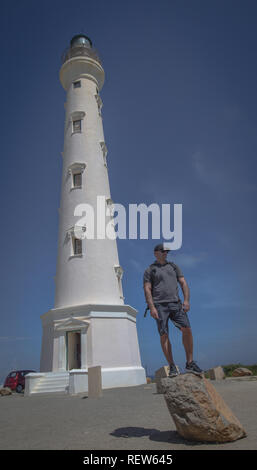 Young explorer and light House in the back Aruba Stock Photo