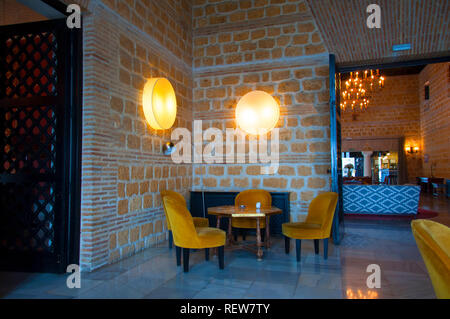 Three yellow velvet chairs and lamps in the corner, hotel interior Stock Photo