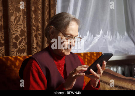 old woman using ebook reader Stock Photo