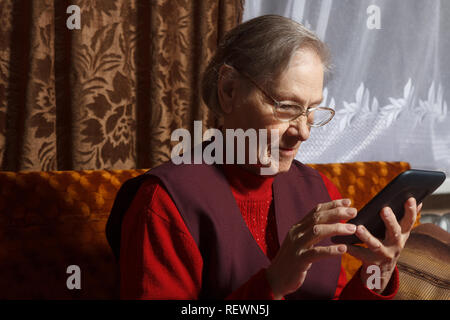 old woman using ebook reader Stock Photo