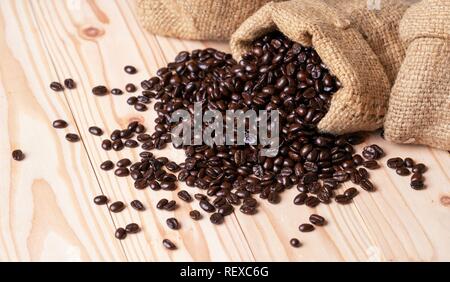 Coffee beans spilled out from burlap sack Stock Photo