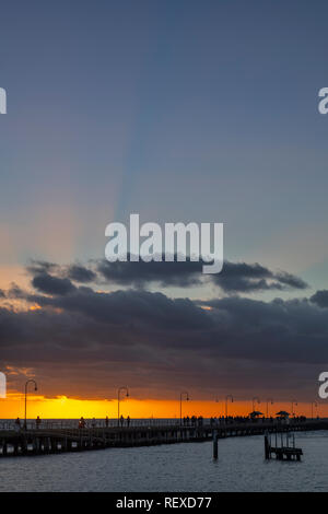Sun setting over Port Phillip Bay with St. Kilda pier in foreground. Stock Photo