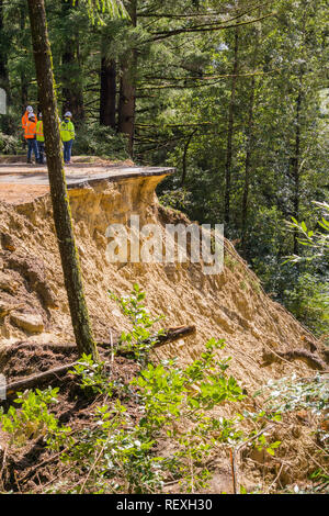 March 27, 2017 Los Gatos/CA/USA - People standing on the edge are discussing solutions regarding a collapsed paved road due to a landslide as result o Stock Photo