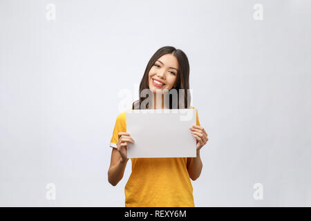 advertising banner sign - woman excited pointing looking empty blank billboard paper sign board. Young business woman isolated on white background Stock Photo