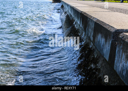 Sea wall at Alki Beach in West Seattle during high tide Stock Photo