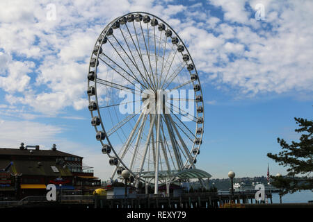 Seattle Big Wheel jumbo ferris wheel on the pier on a partly cloudy day Stock Photo