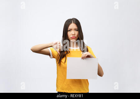 Young caucasian woman holding blank paper sheet over isolated background stressed, shocked with shame and surprise face, angry and frustrated. Fear and upset for mistake. Stock Photo