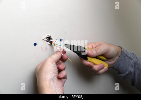 Control wire for thermostat used with a HVAC unit, coming out of wall during installation Stock Photo