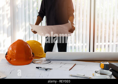 Architect working in a office. Engineer holding blueprint in office, architectural concept Stock Photo
